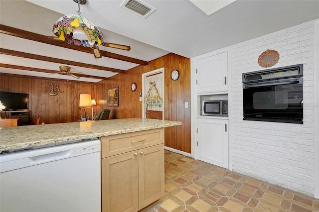 kitchen with white dishwasher, oven, wood walls, a ceiling fan, and stainless steel microwave