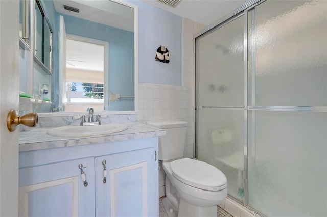 bathroom featuring visible vents, tile walls, toilet, and a shower stall