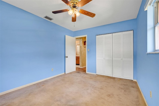 unfurnished bedroom featuring ceiling fan, visible vents, baseboards, a closet, and carpet flooring