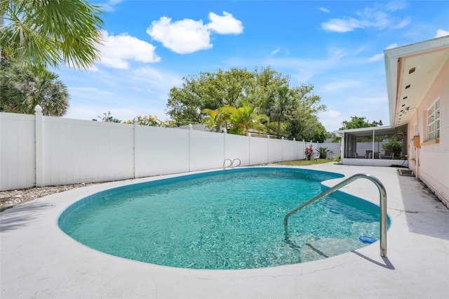 view of swimming pool with a fenced in pool, a fenced backyard, and a sunroom
