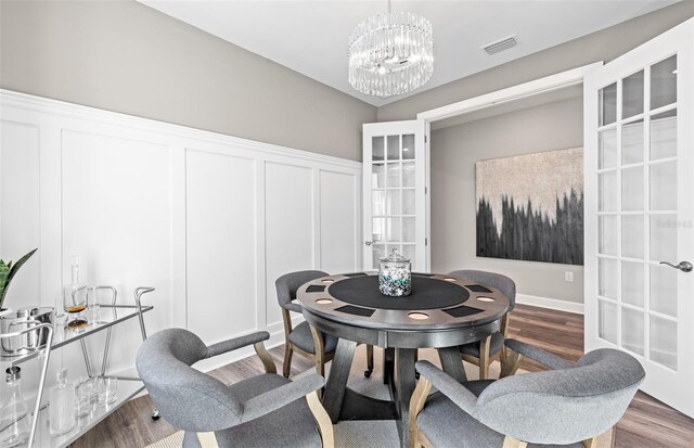 17085 Moonflower Dr, Venice, FL 34293 - dining room featuring visible vents, wood finished floors, an inviting chandelier, and french doors
