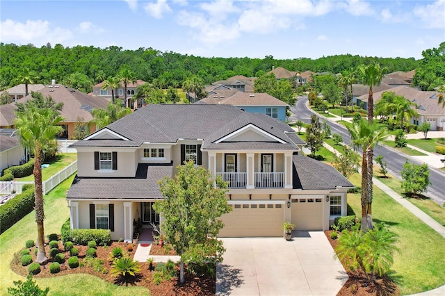 3243 Watermark Dr, Wesley Chapel, FL 33544 - view of front of house with a residential view, concrete driveway, a garage, stucco siding, and a front lawn
