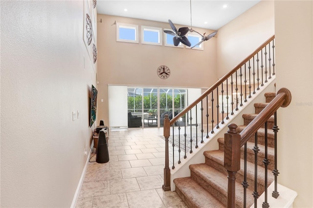 3243 Watermark Dr, Wesley Chapel, FL 33544 - stairs featuring baseboards, a high ceiling, tile patterned floors, and plenty of natural light