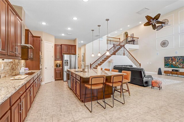 3243 Watermark Dr, Wesley Chapel, FL 33544 - kitchen with a breakfast bar area, a sink, open floor plan, visible vents, and appliances with stainless steel finishes
