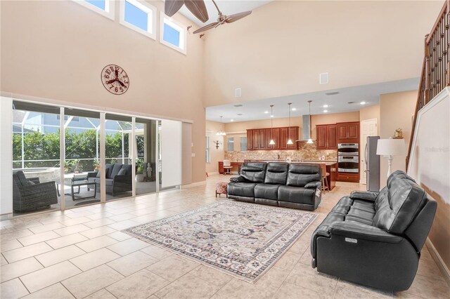 3243 Watermark Dr, Wesley Chapel, FL 33544 - living area featuring baseboards, light tile patterned flooring, ceiling fan, visible vents, and a towering ceiling