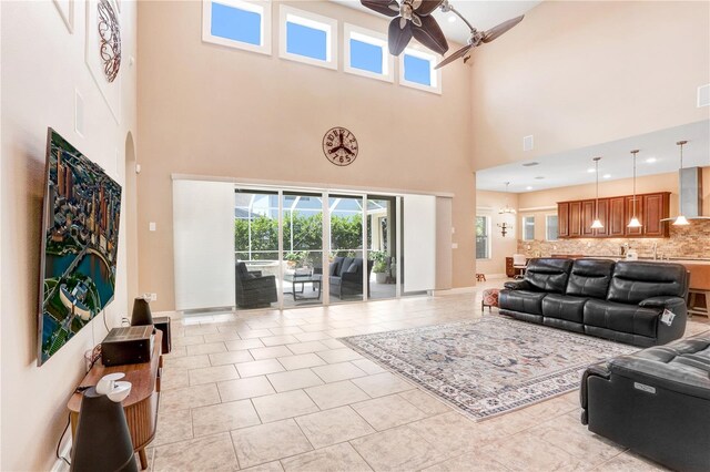 3243 Watermark Dr, Wesley Chapel, FL 33544 - living room with light tile patterned floors, visible vents, ceiling fan, and a towering ceiling