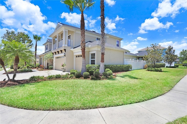 3243 Watermark Dr, Wesley Chapel, FL 33544 - view of property exterior featuring a garage, fence, a lawn, a balcony, and driveway