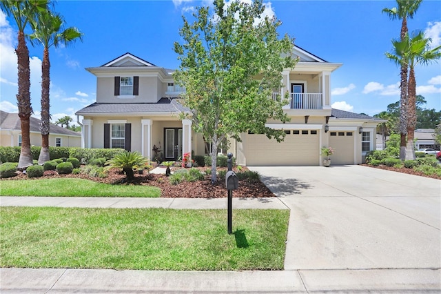 3243 Watermark Dr, Wesley Chapel, FL 33544 - view of front of house featuring an attached garage, a balcony, concrete driveway, stucco siding, and a front yard