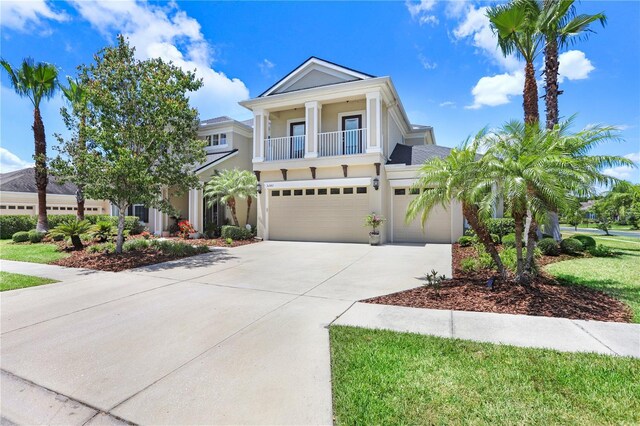 3243 Watermark Dr, Wesley Chapel, FL 33544 - view of front of home with driveway, a garage, stucco siding, and a balcony