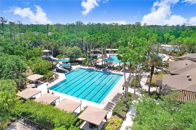 3243 Watermark Dr, Wesley Chapel, FL 33544 - community pool with a wooded view, fence, and a water slide