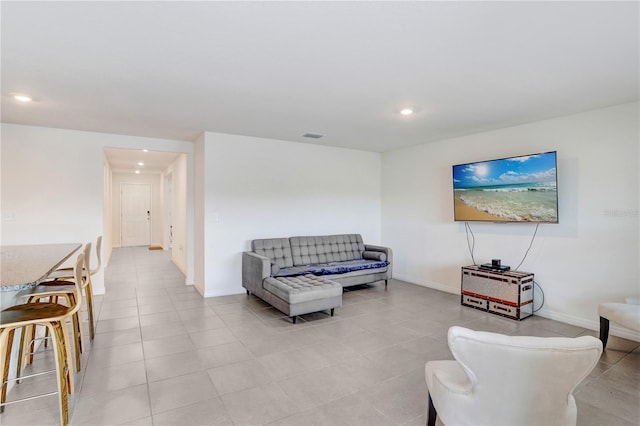 living area featuring light tile patterned flooring, baseboards, and recessed lighting