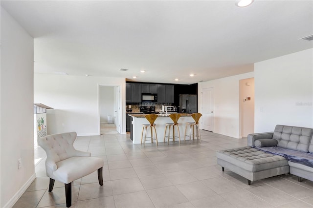 living room featuring light tile patterned floors, baseboards, and recessed lighting