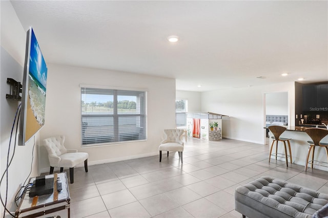 living area with light tile patterned floors, baseboards, and recessed lighting