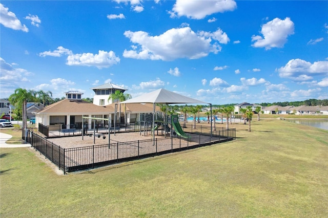 communal playground with a yard, fence, and a water view