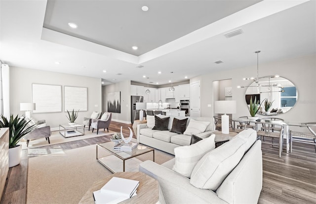 living area featuring a chandelier, visible vents, wood finished floors, and recessed lighting