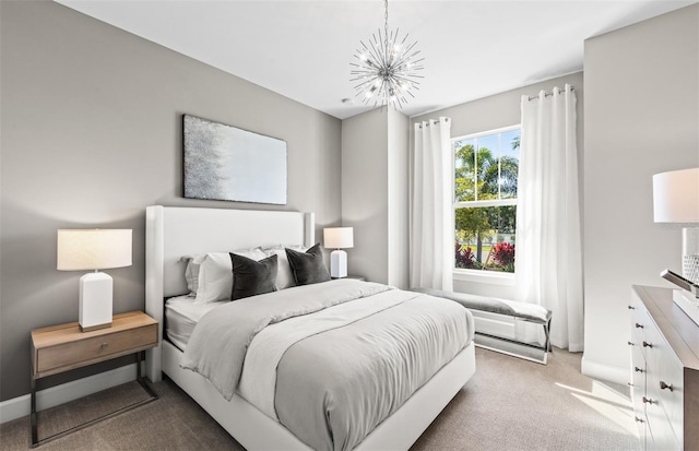 carpeted bedroom with an inviting chandelier and baseboards