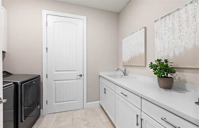 laundry room featuring a sink, washer and dryer, cabinet space, and marble finish floor