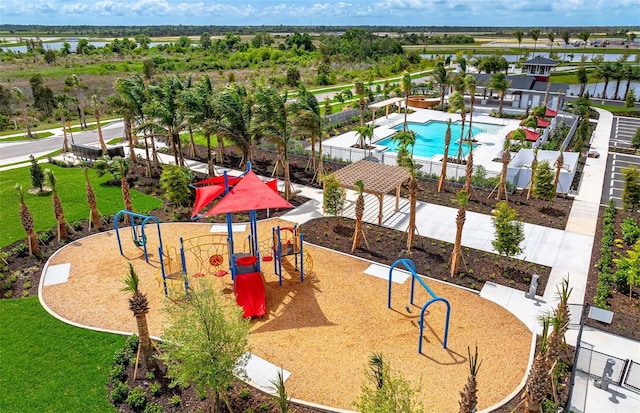community play area featuring fence, a community pool, and a water view