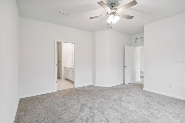 unfurnished bedroom with baseboards, visible vents, light carpet, and connected bathroom