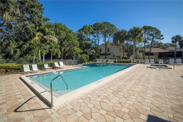 community pool featuring fence and a patio