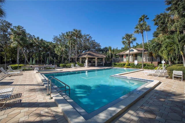 community pool featuring fence, a gazebo, and a patio area