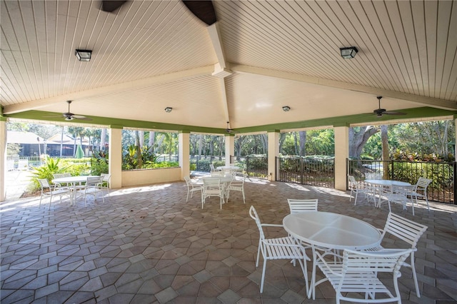 view of patio with fence, a ceiling fan, and outdoor dining space
