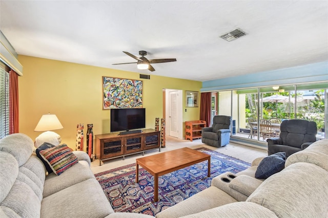 living room featuring visible vents, a ceiling fan, and carpet flooring