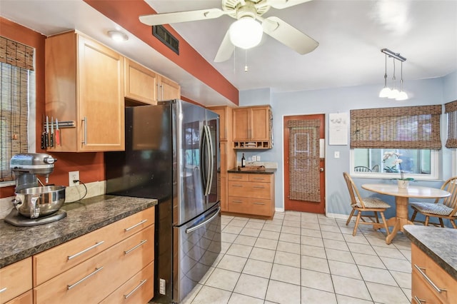 kitchen with dark countertops, light tile patterned flooring, ceiling fan, and freestanding refrigerator