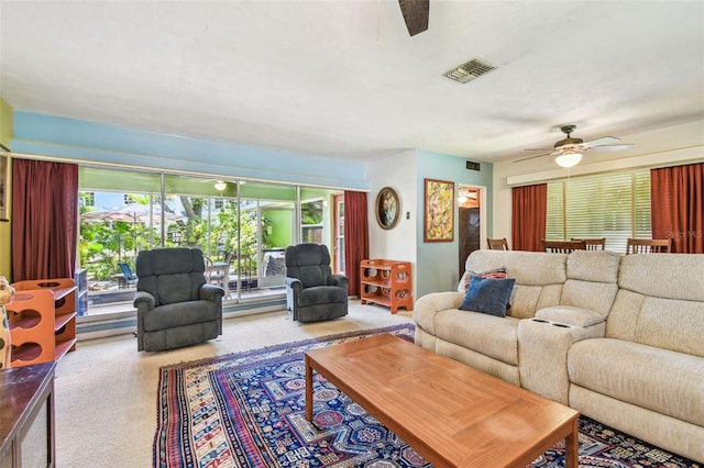 carpeted living area with visible vents and ceiling fan