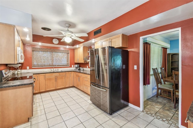 kitchen with a sink, stainless steel appliances, light brown cabinetry, a ceiling fan, and visible vents