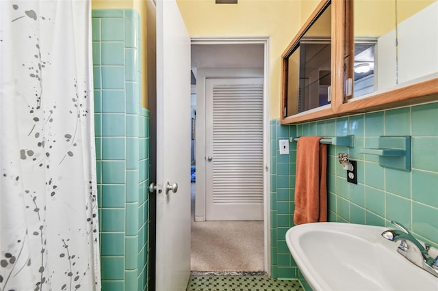 full bathroom with tile walls, a shower with curtain, tile patterned flooring, and a sink