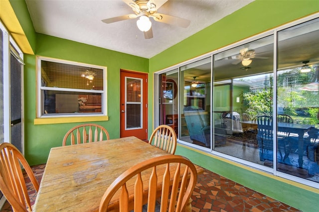 sunroom with a ceiling fan and outdoor dining area