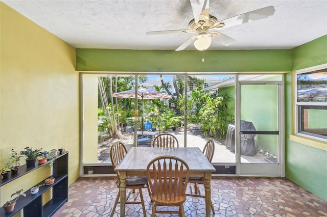 sunroom / solarium with outdoor dining area and ceiling fan