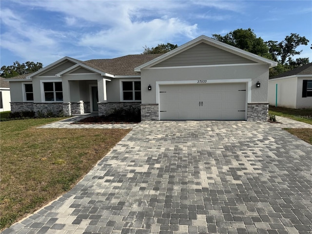 craftsman inspired home featuring stucco siding, decorative driveway, a garage, stone siding, and a front lawn