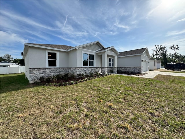 view of front facade featuring fence, stucco siding, driveway, and stone siding