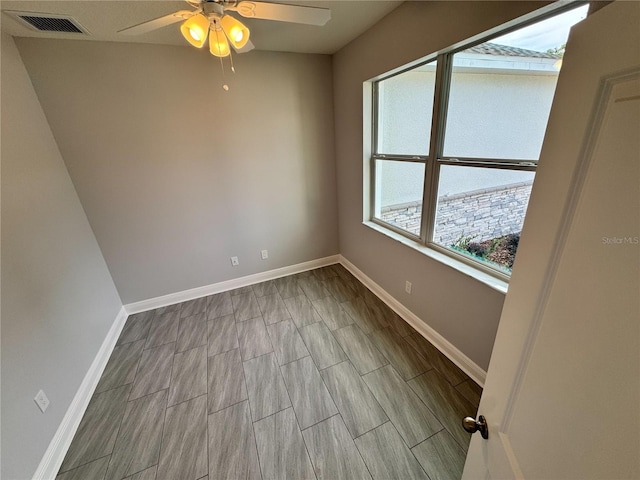 unfurnished room with visible vents, ceiling fan, and baseboards