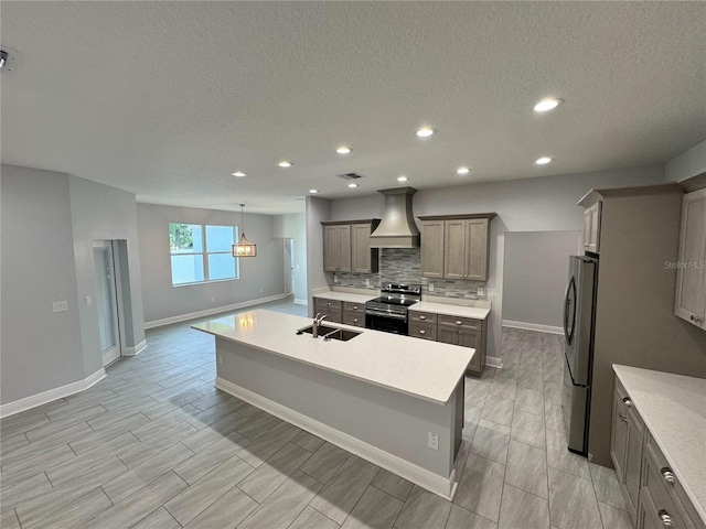 kitchen with a sink, custom range hood, stainless steel appliances, and baseboards