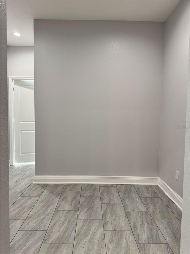 spare room featuring recessed lighting and baseboards