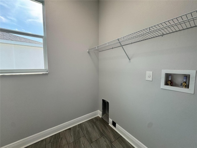 washroom with hookup for a washing machine, hookup for an electric dryer, laundry area, and baseboards