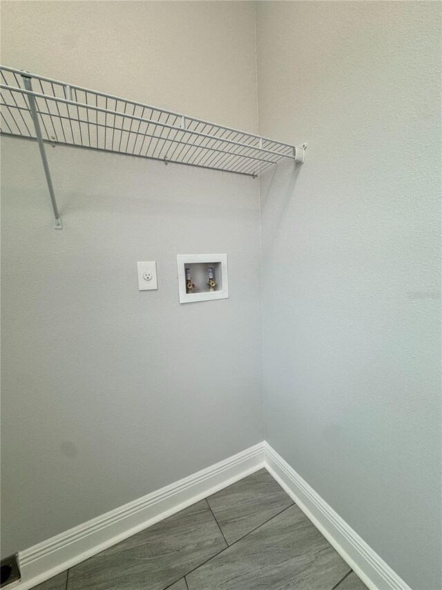 washroom featuring electric dryer hookup, washer hookup, laundry area, and baseboards