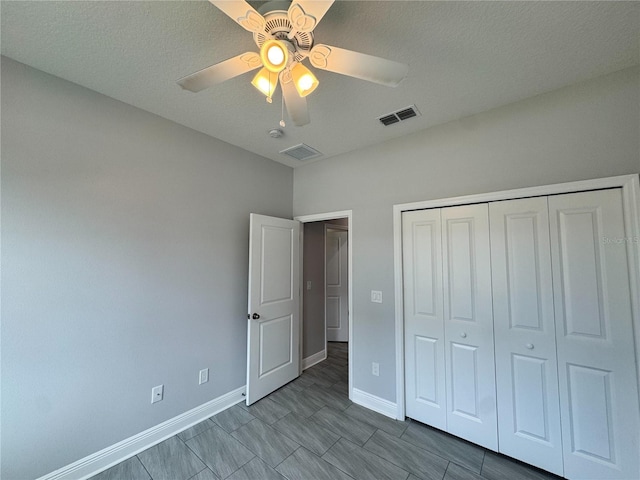 unfurnished bedroom with baseboards, visible vents, a ceiling fan, and a closet
