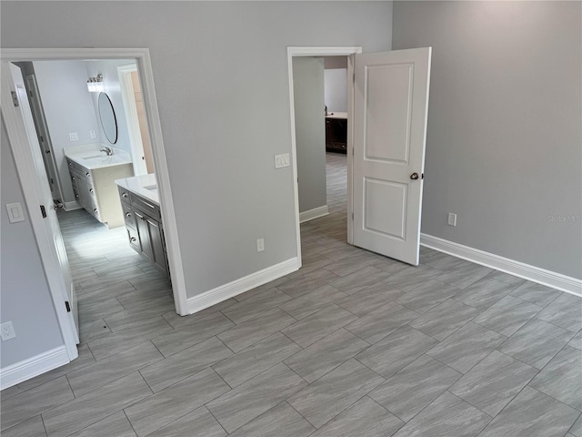 unfurnished bedroom with baseboards and a sink