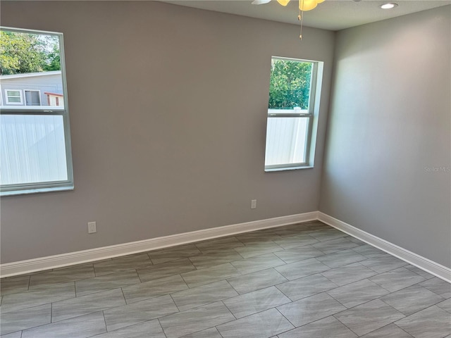 empty room featuring ceiling fan and baseboards