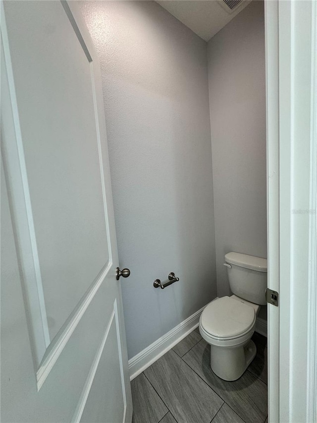 bathroom with toilet and baseboards