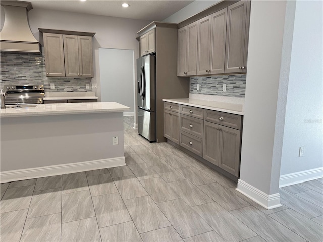 kitchen featuring stainless steel appliances, decorative backsplash, custom range hood, baseboards, and light countertops