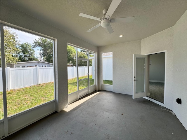 unfurnished sunroom featuring ceiling fan