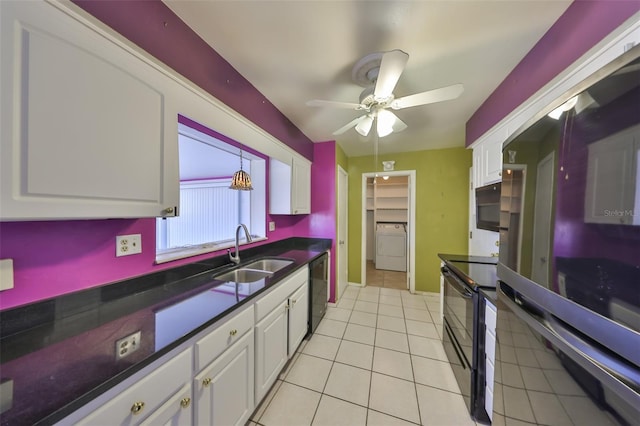 kitchen featuring dark countertops, a sink, washer / clothes dryer, white cabinetry, and black appliances