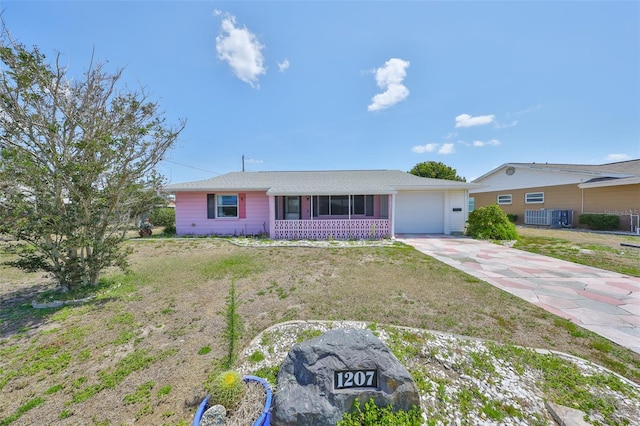 ranch-style home with concrete driveway, a sunroom, an attached garage, and central AC