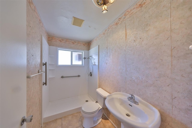 full bath with a sink, a stall shower, toilet, and visible vents