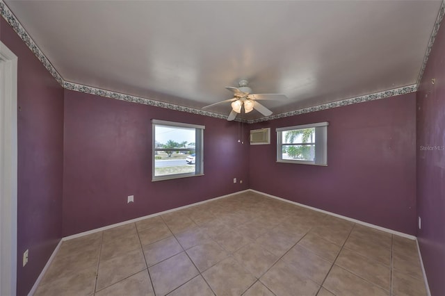 tiled empty room with baseboards and a ceiling fan